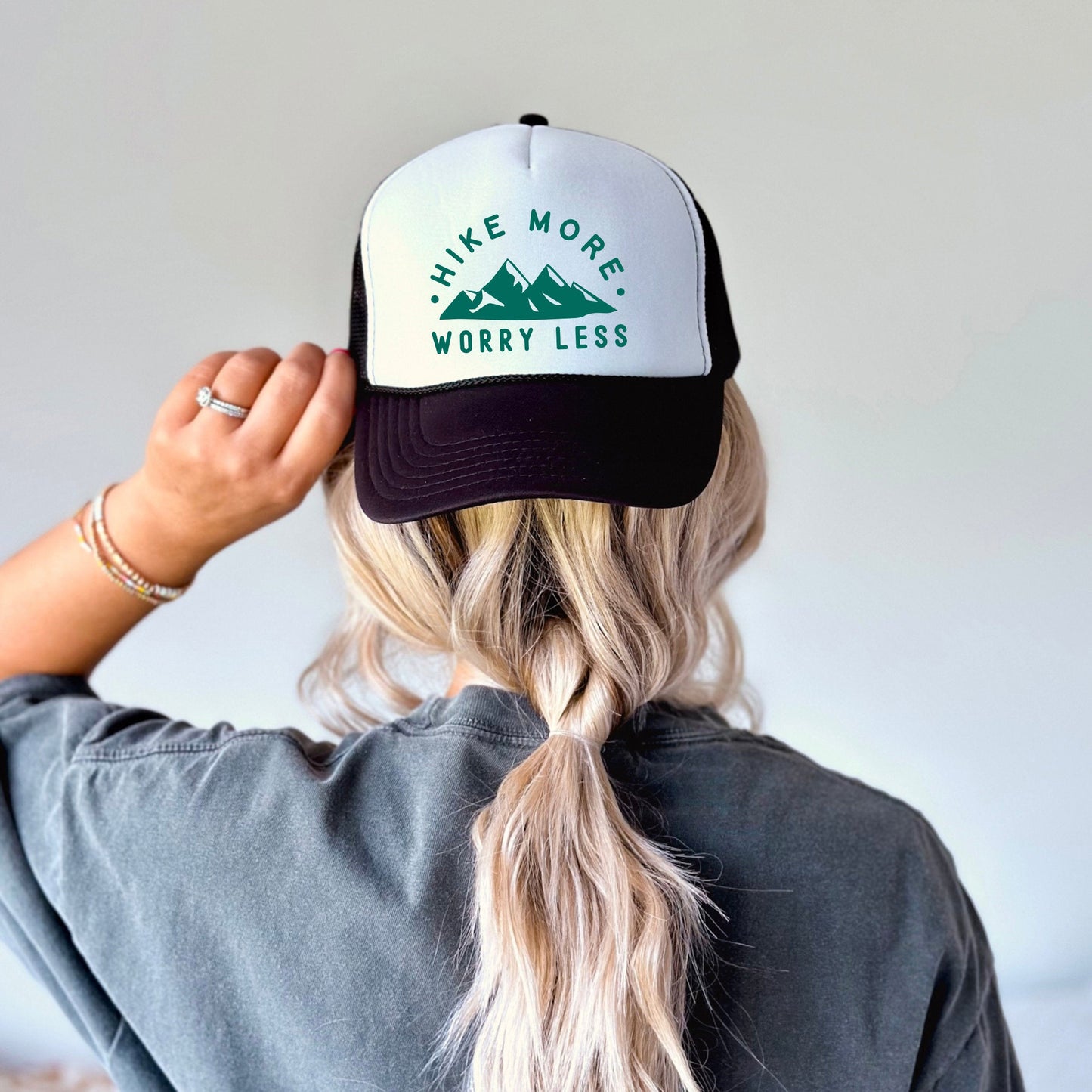 the back of a woman's head wearing a hat that says hike more worry
