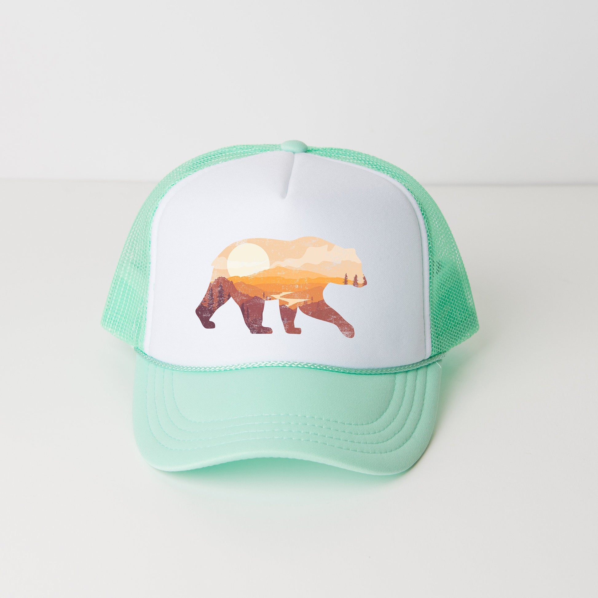 a green and white hat with a picture of a bear on it