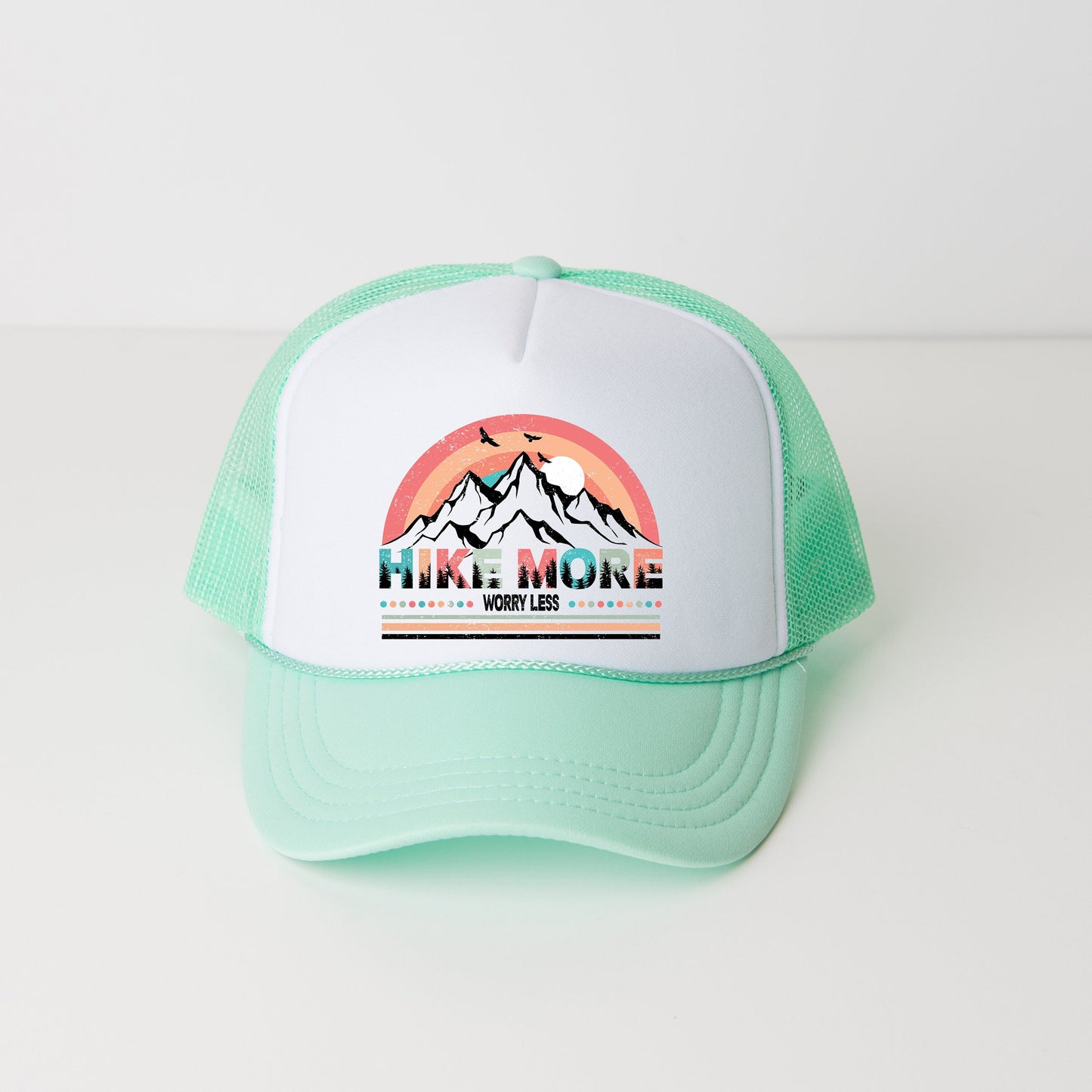 a green and white trucker hat with a picture of a mountain