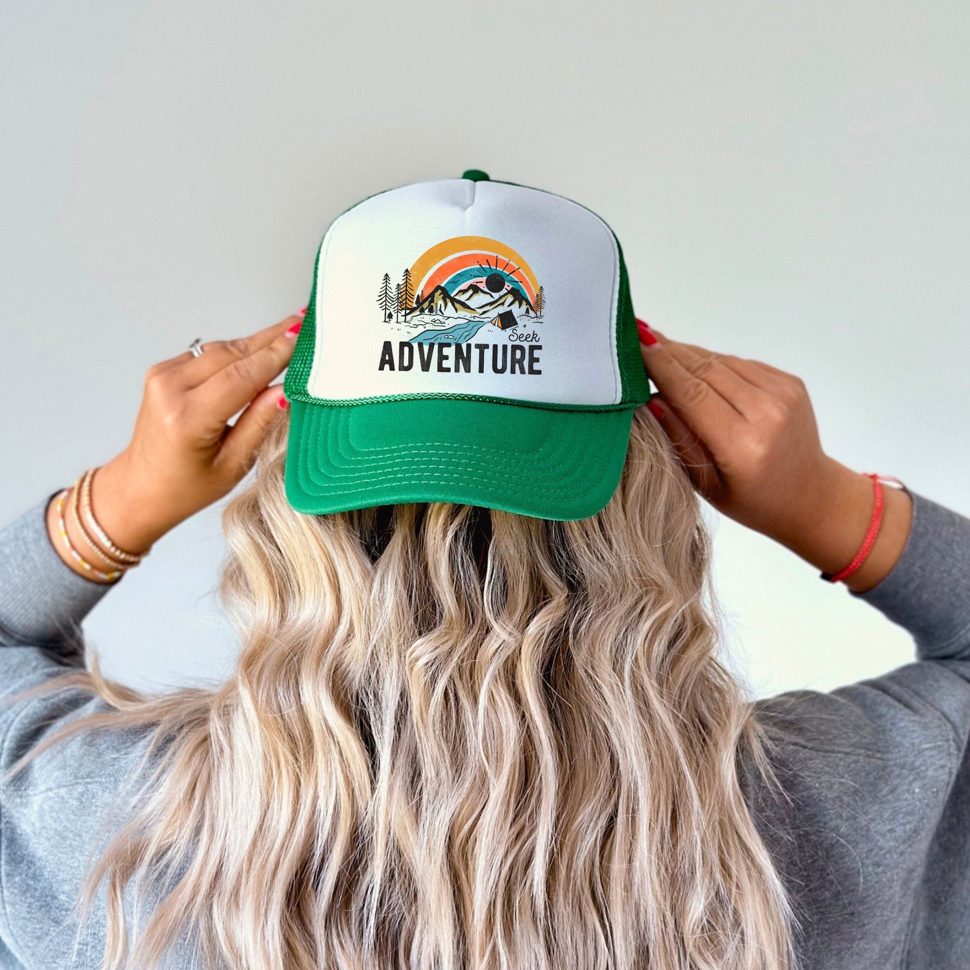 a woman wearing a hat with the words adventure on it
