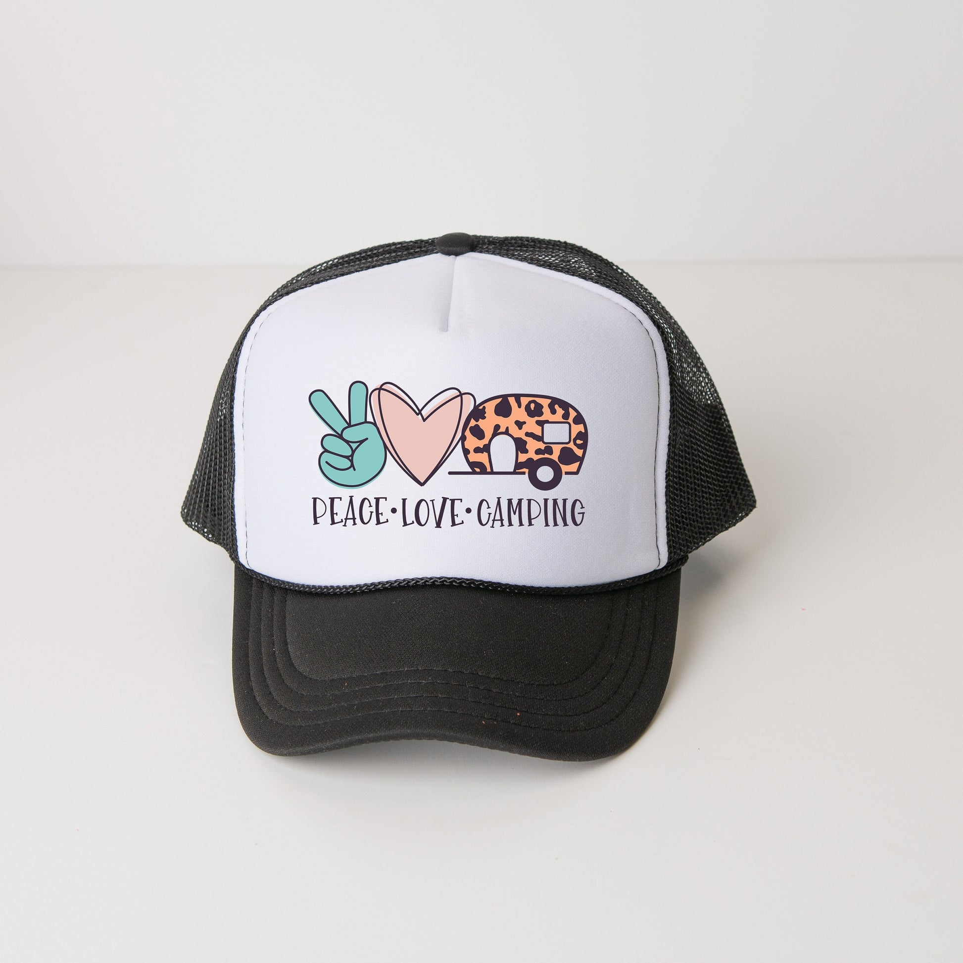 a black and white trucker hat with a peace love camping design