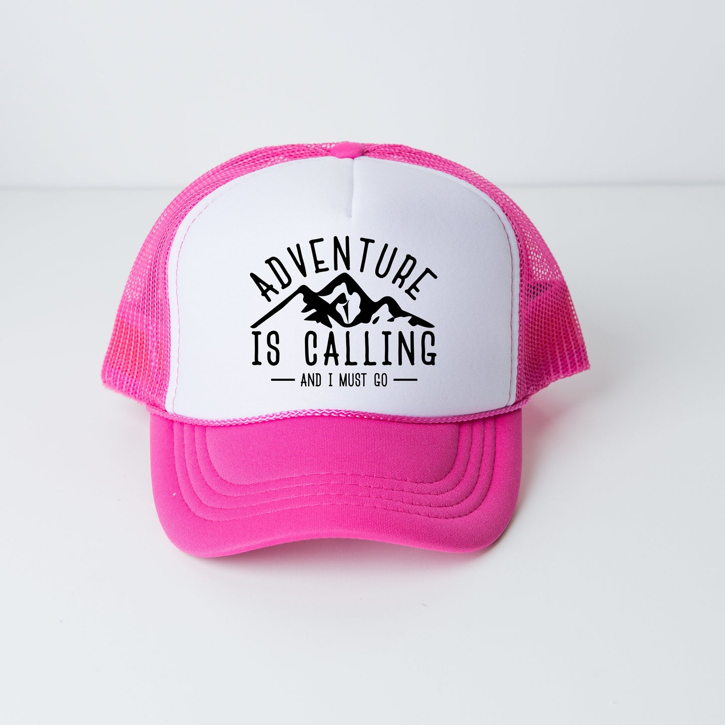a pink and white trucker hat that says adventure is calling and i must go