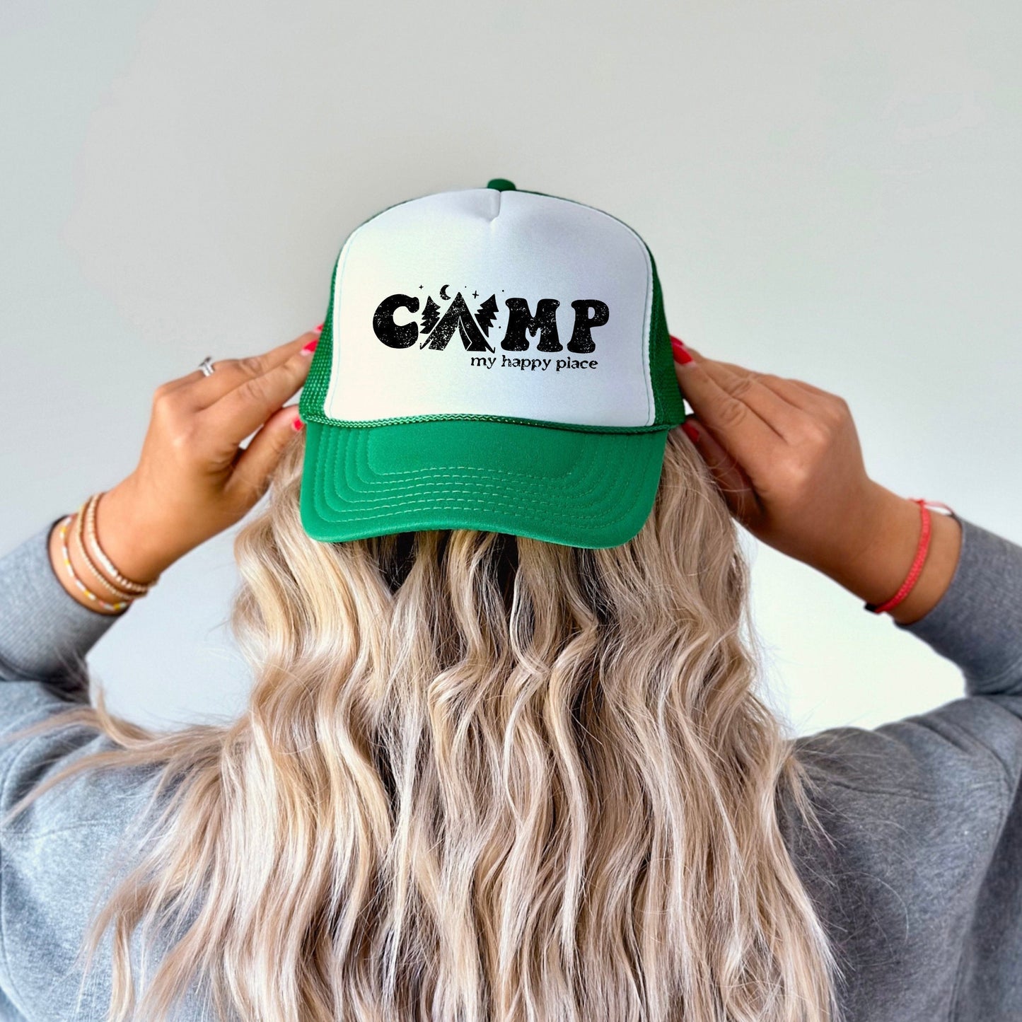 a woman wearing a green and white camp hat