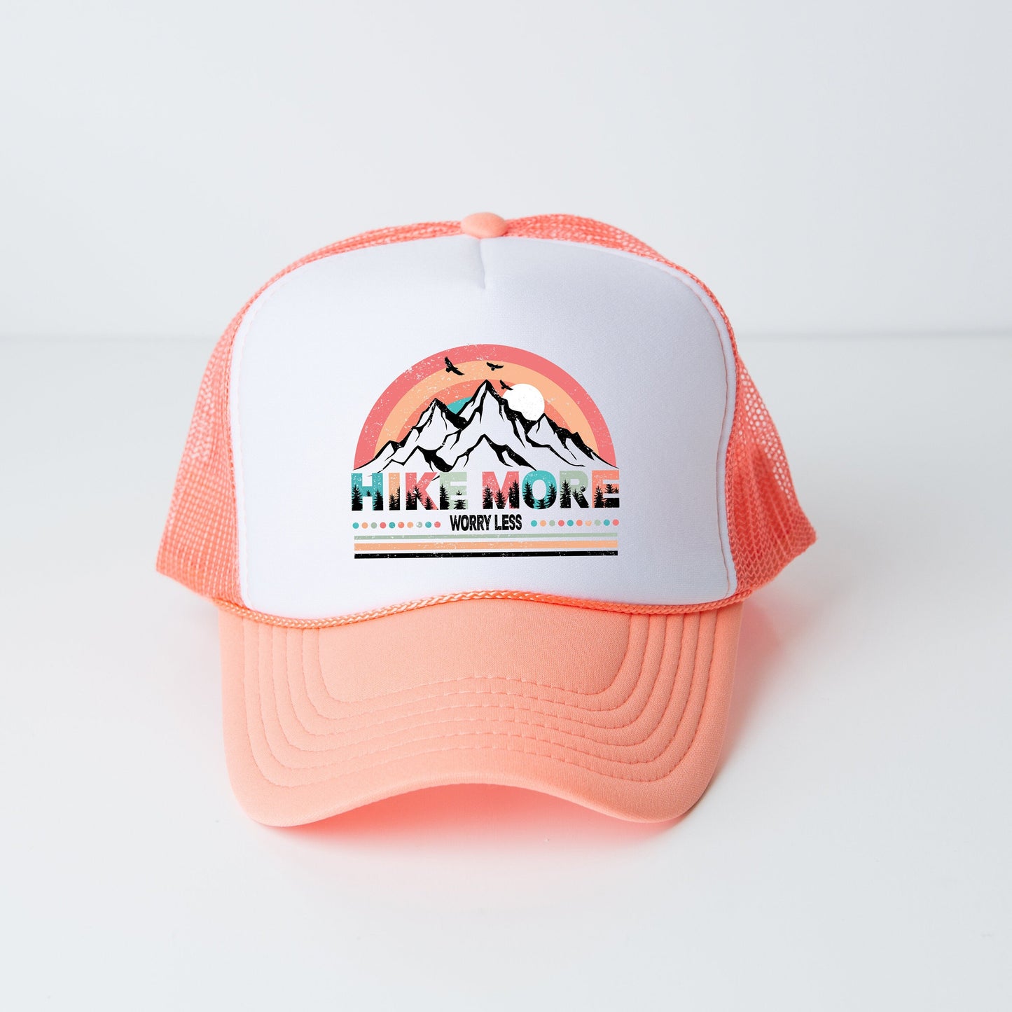 a pink and white trucker hat with a mountain scene