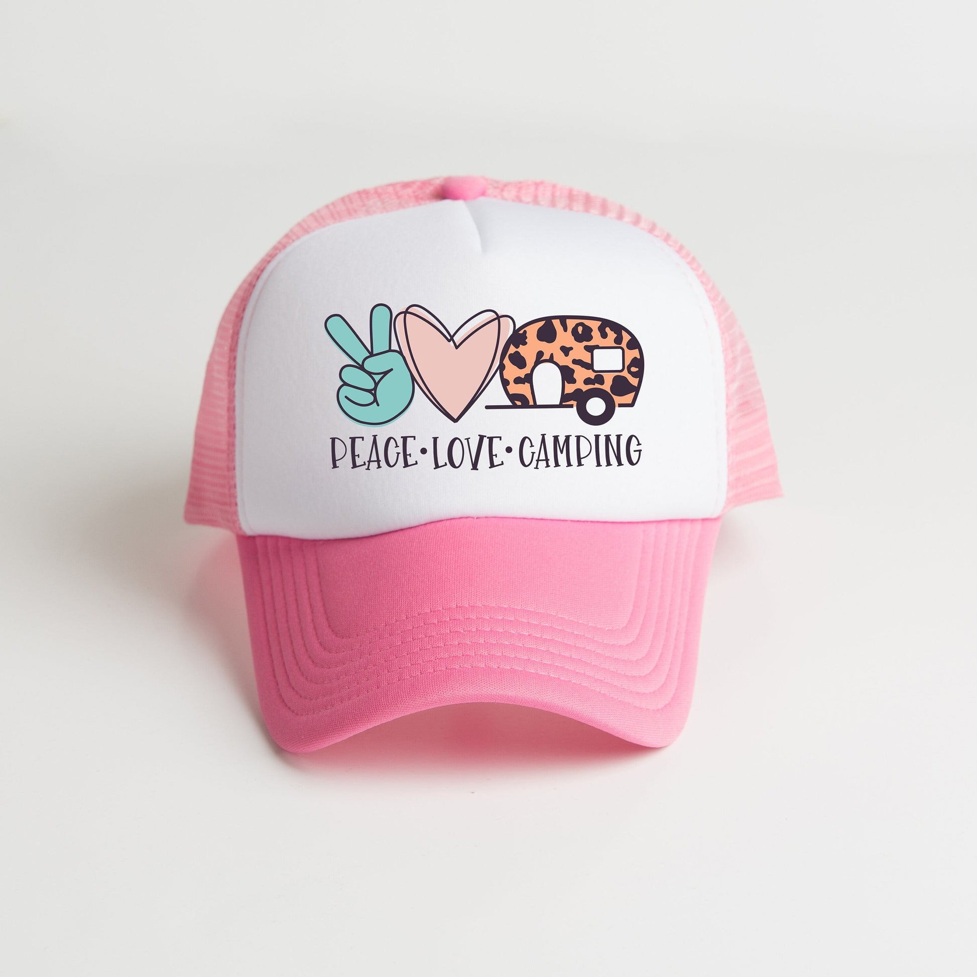 a pink and white trucker hat with a peace love game on it
